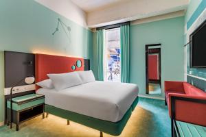a bedroom with a white bed and a red chair at Room Mate Bruno, Rotterdam in Rotterdam