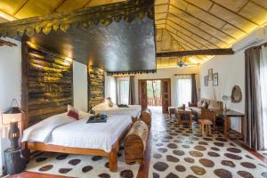 a bedroom with two beds and a living room at Bong Thom Forest Lodge in Siem Reap