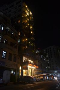 un edificio alto con luces encendidas por la noche en Hotel Nikko Towers, en Dar es Salaam