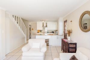 sala de estar con muebles blancos y cocina en Nansen Place, en Ciudad del Cabo