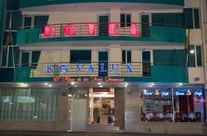 un edificio con un letrero de neón que lee novalium en Hotel Novalux, en Ambato