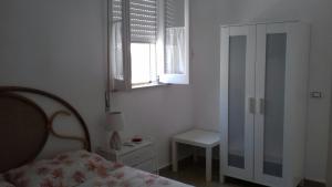 a bedroom with a bed and a window and a chair at Casa Mare Ognina in Ognina