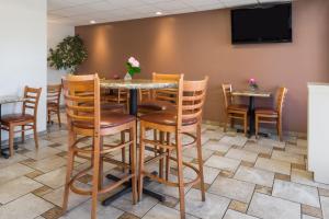 comedor con mesa, sillas y TV en Laurel Inn & Conference Center, en Salinas