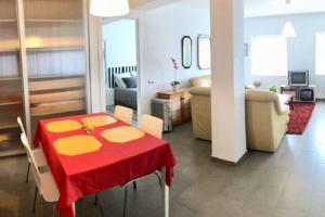 a living room with a red and yellow table and chairs at La Casa de Antón in Tineo