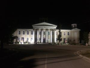 a large white building with a lit up front at night at Dos Guesthouse in Bishkek