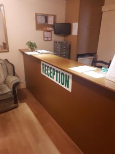 an reception desk in an office with a sign on it at Shamrock Guest House in Gravesend