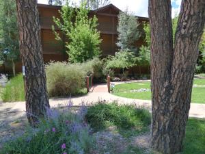 a garden with purple flowers in front of a building at Ruidoso River Resort Condos in Ruidoso