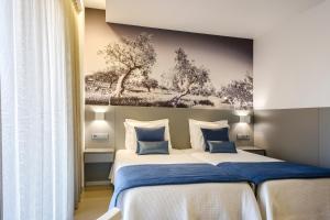 ein Schlafzimmer mit 2 Betten und einem Wandgemälde in der Unterkunft Serra d'Aire Boutique Hotel - SA Hotels in Fátima