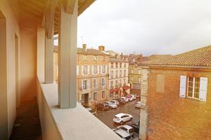 uma vista para um parque de estacionamento a partir de uma varanda de um edifício em Hôtel Alchimy em Albi