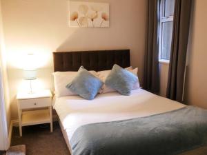 a bedroom with a bed with blue pillows and a window at Townhouse Tullamore in Tullamore