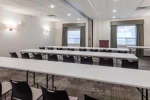 une salle de conférence avec des tables et des chaises blanches dans l'établissement Ramada by Wyndham Revelstoke, à Revelstoke