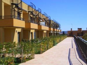 a walkway next to a building with a fence at Masia Blanca - Coma-ruga in Comarruga