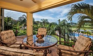 a balcony with a glass table and two chairs at Ocean View Condo in Los Sueños in Herradura