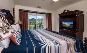 a bedroom with a bed and a tv in a room at Ocean View Condo in Los Sueños in Herradura