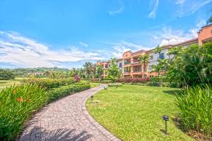 a brick walkway in a park next to a building at Ocean View Condo in Los Sueños in Herradura