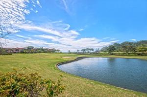 a view of a pond on a golf course at Ocean View Condo in Los Sueños in Herradura