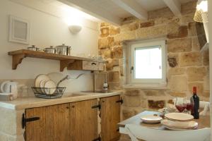 a kitchen with a sink and a table with dishes at Casa Regina Paola in Monopoli +15 photos