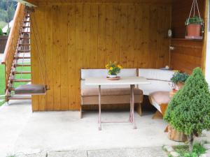 a patio with a table and a swing at Apartmány pri Studničke in Oravský Biely Potok