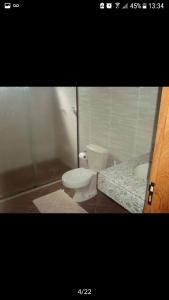 a bathroom with a toilet and a sink at Chacara Recanto dos Passaros 01 in Olímpia