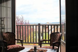a balcony with two chairs and a table and a window at Dúplex en Badaguás, Jaca in Badaguás