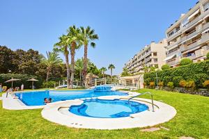 a large swimming pool in a yard with palm trees at Beferent Riviera Blanca Golf - Playa in Alicante