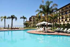 a large swimming pool with chairs and an umbrella at Terranea Resort in Rancho Palos Verdes