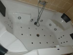 a white bath tub with a shower in a bathroom at Casa Iván in Xert