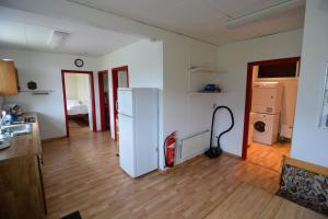 eine Küche mit einem weißen Kühlschrank und einem Staubsauger in der Unterkunft Bragdavellir Holiday Home in Djúpivogur