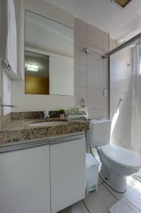 W łazience znajduje się toaleta, umywalka i lustro. w obiekcie Villa Beira Mar w mieście Fortaleza