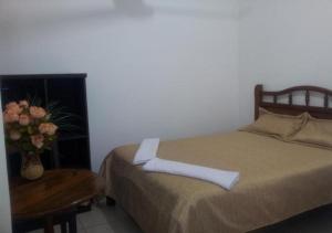 a bedroom with a bed and a table and flowers at Residencial IKANDIRE ll in Santa Cruz de la Sierra