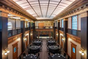 a room with tables and chairs in a building at One King West Hotel and Residence in Toronto