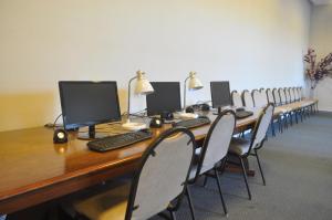 a conference room with a long wooden table with computers on it at Hotel Las Rocas in Mar del Plata +97 photos