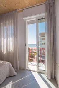 una camera da letto con una grande finestra con vista sull'oceano di Hotel Atene a Lido di Jesolo