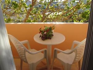 a table and chairs with a flower arrangement on a balcony at Athina in Rethymno Town +105 photos
