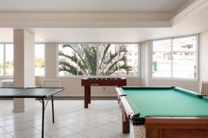 a pool table in a room with windows at Apartamento Ingleses Norte in Florianópolis