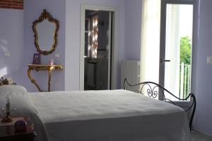 Schlafzimmer mit einem Bett, einem Spiegel und einem Fenster in der Unterkunft La Granda agrirelax in San Martino Alfieri