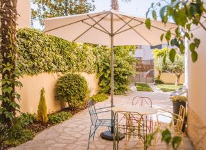un tavolo e sedie sotto un ombrellone su un patio di El jardí de l'avet a Lleida