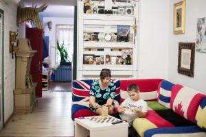 a woman sitting on a couch next to a child at Scotch Hostel in Volgograd