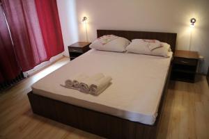 a bedroom with a bed with towels on it at Restoran sa prenoćištem Žitište in Žitište