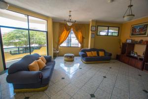 a living room with two couches and a large window at Hostal Andry in Puerto Baquerizo Moreno
