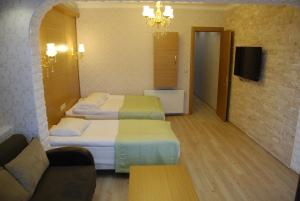 イスタンブールにあるザ ポート ホテルのベッド2台とソファが備わるホテルルームです。