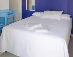 uma grande cama branca com duas toalhas em Hotel Gandhi em Jacutinga
