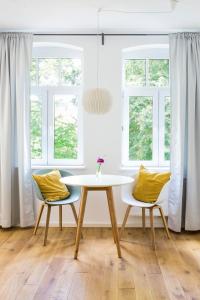 a table and two chairs in a room with windows at Gästezimmer St. Dionys in Sankt Dionys