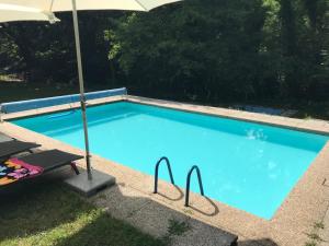 a large blue swimming pool with an umbrella at Casa Parentela in Ligornetto