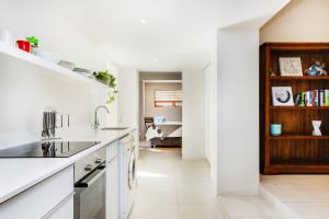 a white kitchen with a sink and a counter at Cheviot Place Garden Apartment with Private Entrance in Cape Town