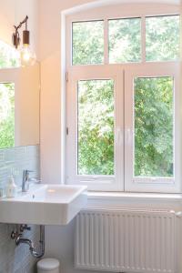 a bathroom with a sink and two windows at Gästezimmer St. Dionys in Sankt Dionys