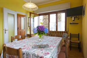 een eettafel met een vaas met bloemen erop bij Casa Bougainville in Cannobio