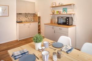 a kitchen with a wooden table with a microwave at TOP-Lage, 400 m bis GOP, Bali-Therme und Kurpark - HDZ - Parkplatz in Bad Oeynhausen +36 photos
