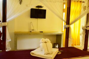- un animal de serviettes assis sur un lit dans une pièce dans l'établissement Safari Queens Resort, à Uda Walawe