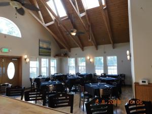 un comedor con mesas y sillas azules y ventanas en Freeport Wine Country Inn, en Freeport